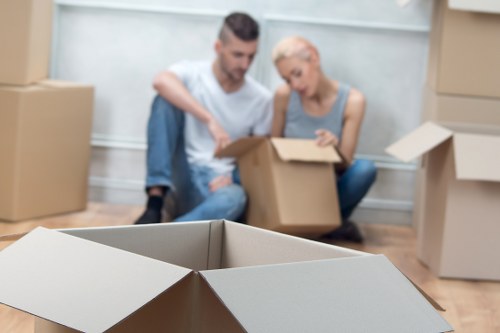 Professional movers handling furniture in a Queens Park flat removal