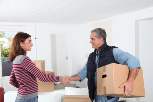 Helper carrying boxes during a move in Queens Park