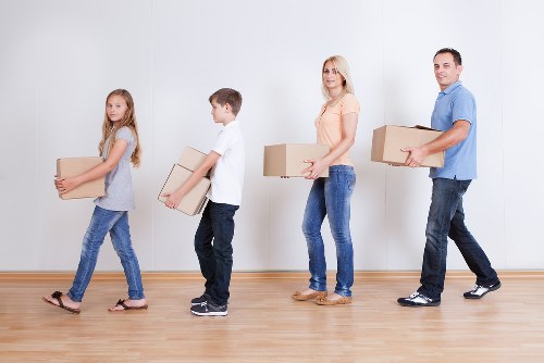 Professional movers unloading office items at a Queens Park workplace
